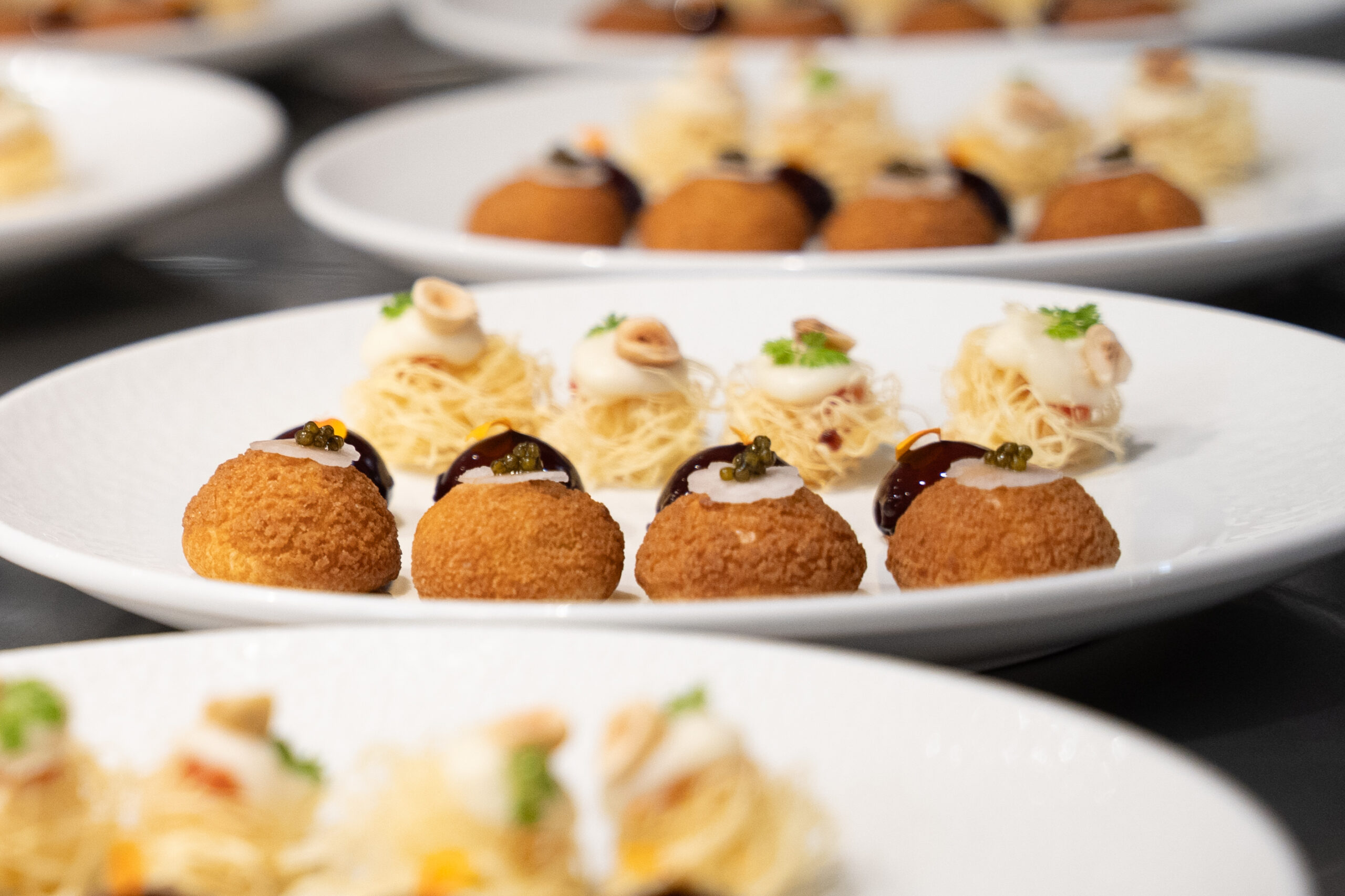 Assorted French canapés including crispy croquettes and layered pastry bites